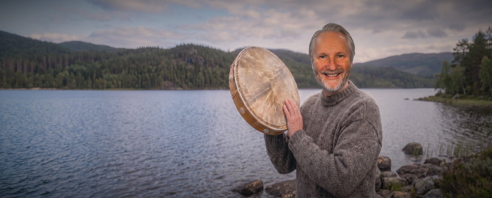 Pål-Esben Wanvig con un tambor junto a un lago en el bosque.